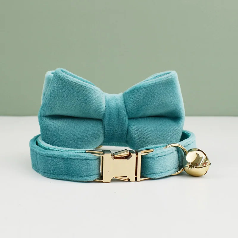 KittyNook Cat Co.'s Velvet Cat Collar in teal features a bow, gold buckle, and bell for soft, stylish comfort.