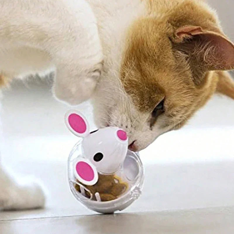 A cat sniffs the KittyNook Cat Co. Non-Toxic Pet IQ Food Leak Tumbler on a light-colored floor.