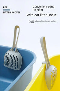 Thumbnail for Two Curved Cat Litter Shovels by KittyNook Cat Co. hang on blue and yellow bins for easy, odor-free litter cleaning.