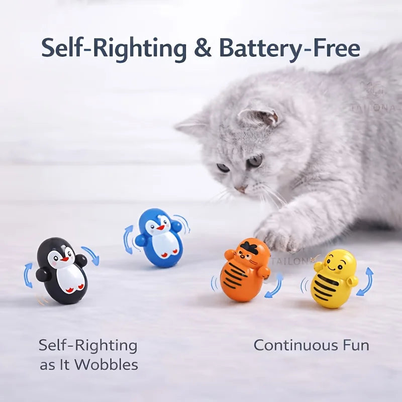 A cat bats at four colorful, wobbling Cat Rolling Toy Set – Self-Rolling Interactive Cat Toys on a light surface.