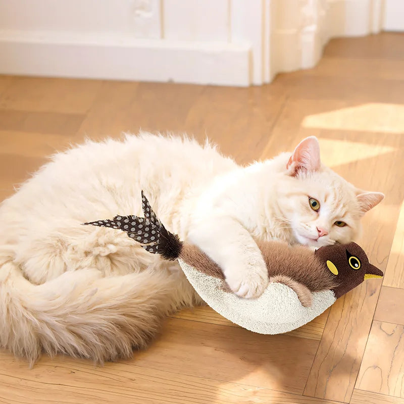 A fluffy white cat hugs a Squeaky Plush Cat Toy by KittyNook Cat Co., enjoying cozy mental stimulation.