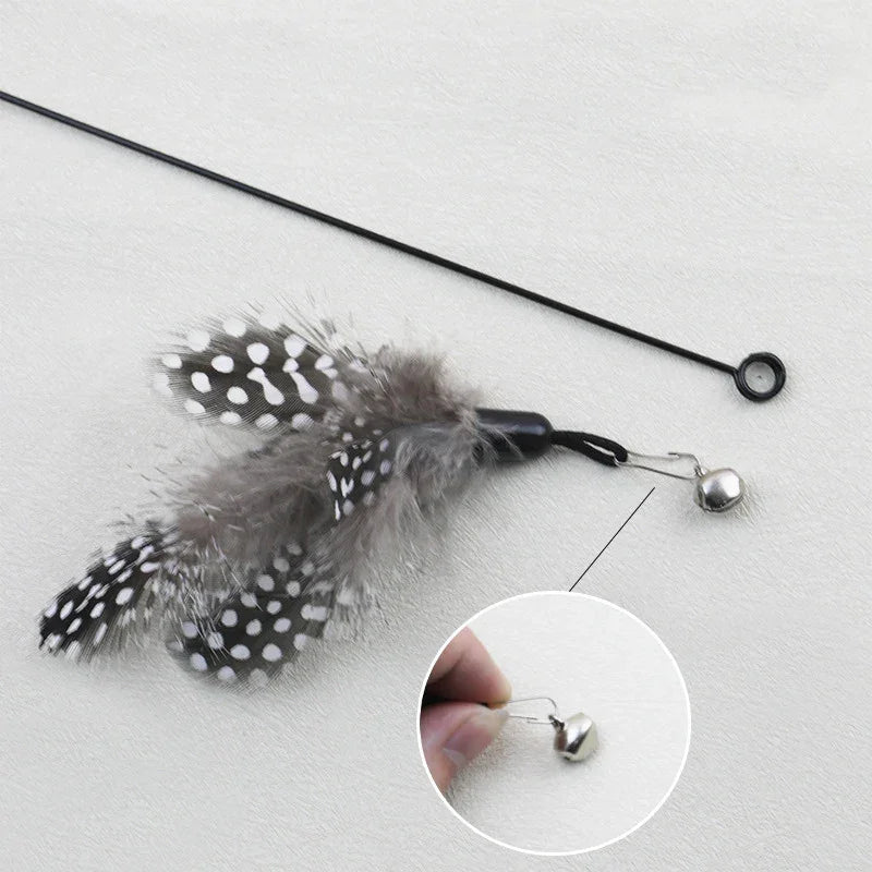 KittyNook Cat Co. Eco-Friendly Wood & Feather Cat Teaser features a close-up of the detailed silver bell attachment.