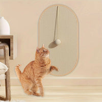 Thumbnail for An orange tabby cat touches the KittyNook Cat Co. Durable Sisal Cat Scratch Pads with a hanging ball on the wall.