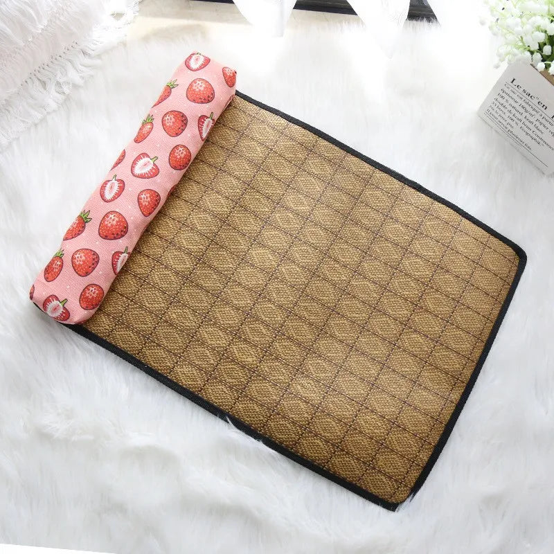KittyNook Cat Co. Natural Rattan Cat Sleeping Mat: brown woven mat with pink strawberry pillow on white surface.