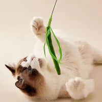 Thumbnail for A fluffy cat lies on its back, reaching for KittyNook Cat Co.'s Feather Wand: Fun & Fitness Combined toy above it.