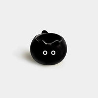 Thumbnail for The KittyNook Cat Co. Siamese Cat Coffee Cup is a small black mug with white eyes, shaped like a cat's head.