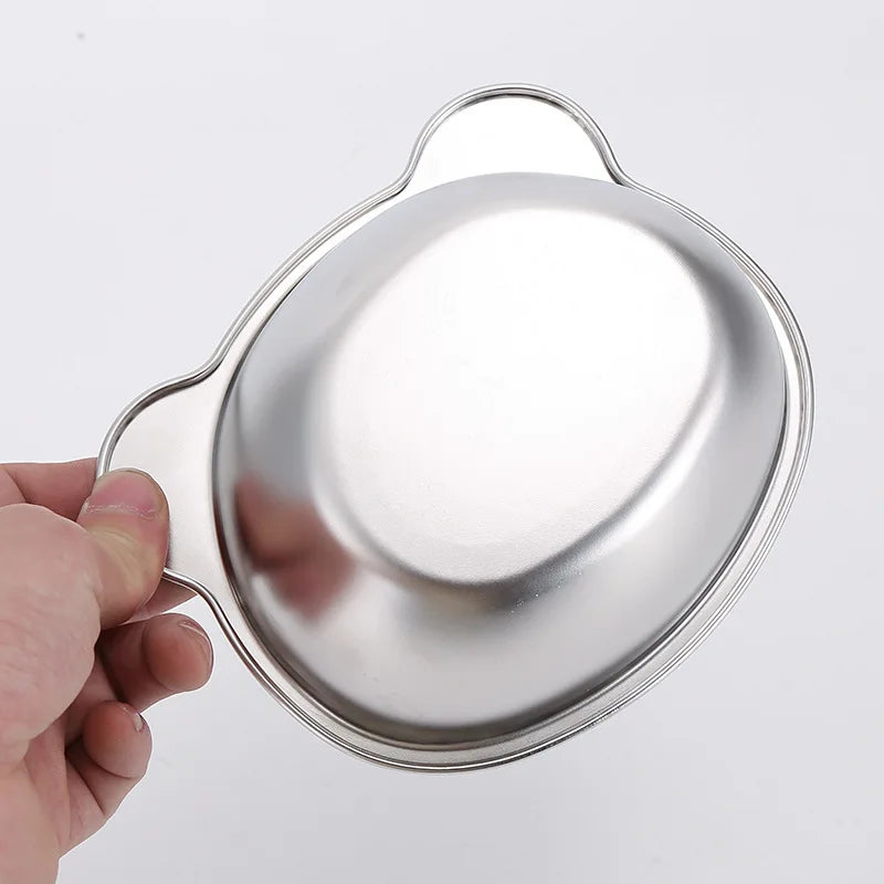 A hand holds the KittyNook Cat Co. Ergonomic Tilted Stainless Steel Cat Bowl against a white background.