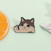 Thumbnail for Kawaii Thumbs Up Crying Cat Enamel Pin by KittyNook Cat Co. with orange slice on pale green background.
