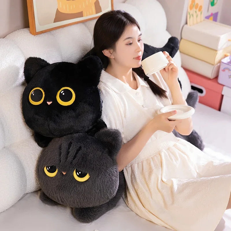 A woman in white relaxes on a couch with two KittyNook's Plush Cat Pillow: Whimsical Home Cozy—perfect cat lover gifts.