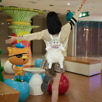 Thumbnail for A person with outstretched arms wears The Purrfect Cat Lover’s Bag by KittyNook Cat Co. in a colorful play area.