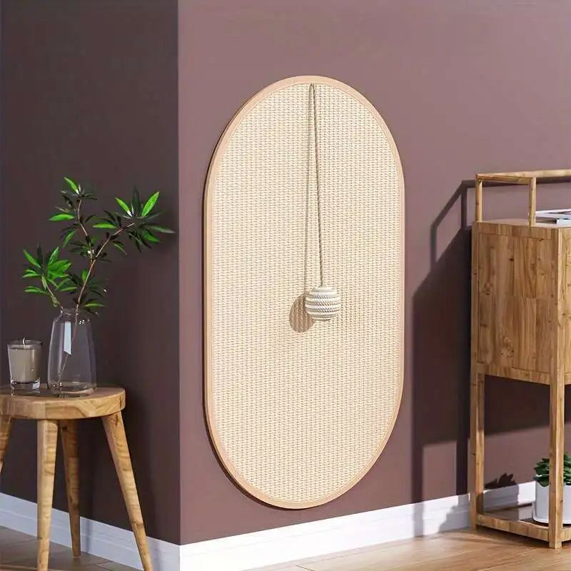 KittyNook Cat Co. Durable Sisal Cat Scratch Pads with hanging ball on a mauve wall near a wooden table and glass planter.