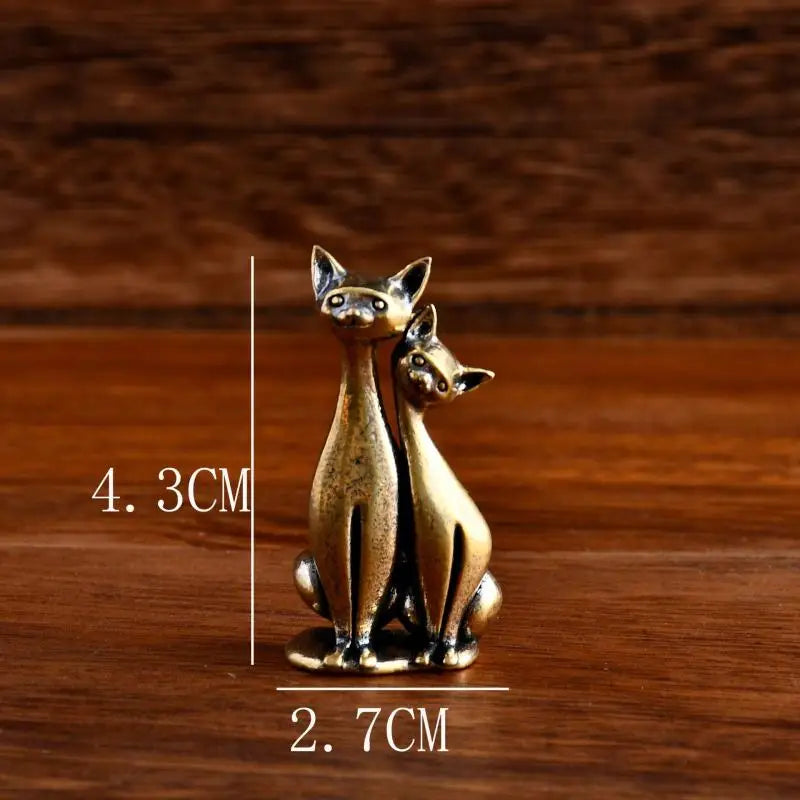 The Intertwined Loving Cats Brass Sculpture by KittyNook Cat Co. adds charm and meaning to any wooden surface.