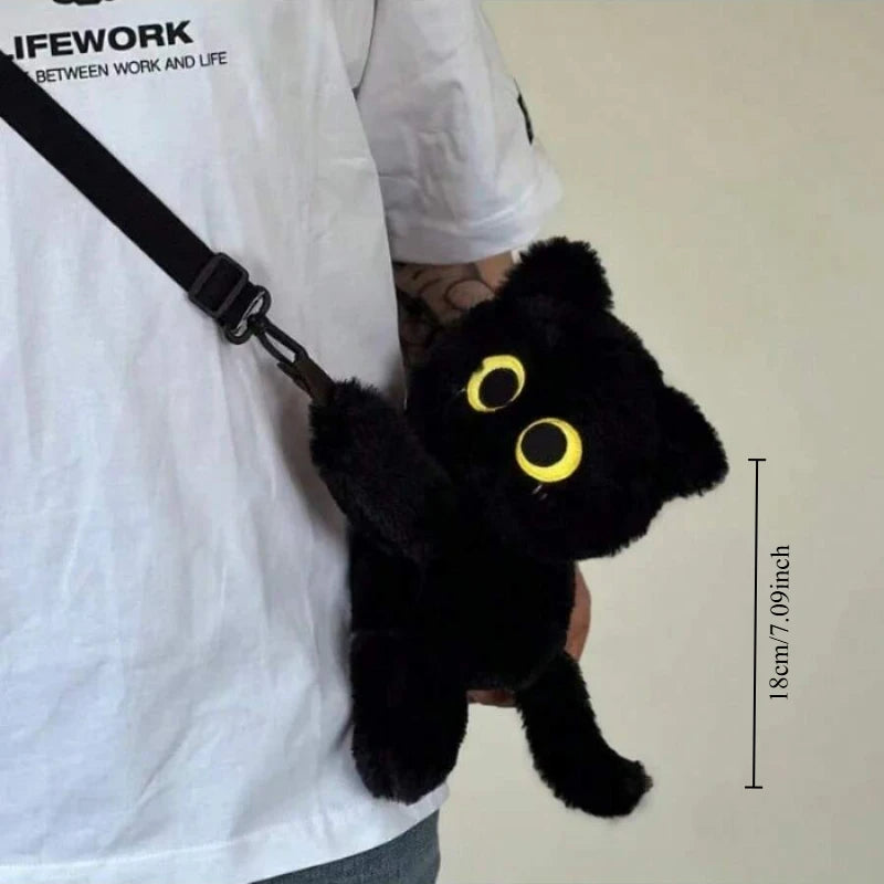 A person holds The Cute Big Eyes Plush Backpack by KittyNook Cat Co., shaped like a black cat and 18cm tall.