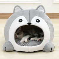 Thumbnail for A gray and white cat relaxes in the KittyNook Cat Co. Fluffy Indoor Cat Cave Bed for Kittens on a wooden floor.