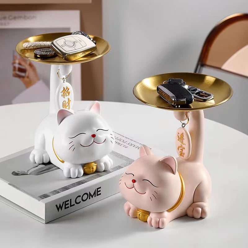 Two Chic Cat Metal Key Trays by KittyNook Cat Co. keep keys and accessories tidy beside a book titled "WELCOME.